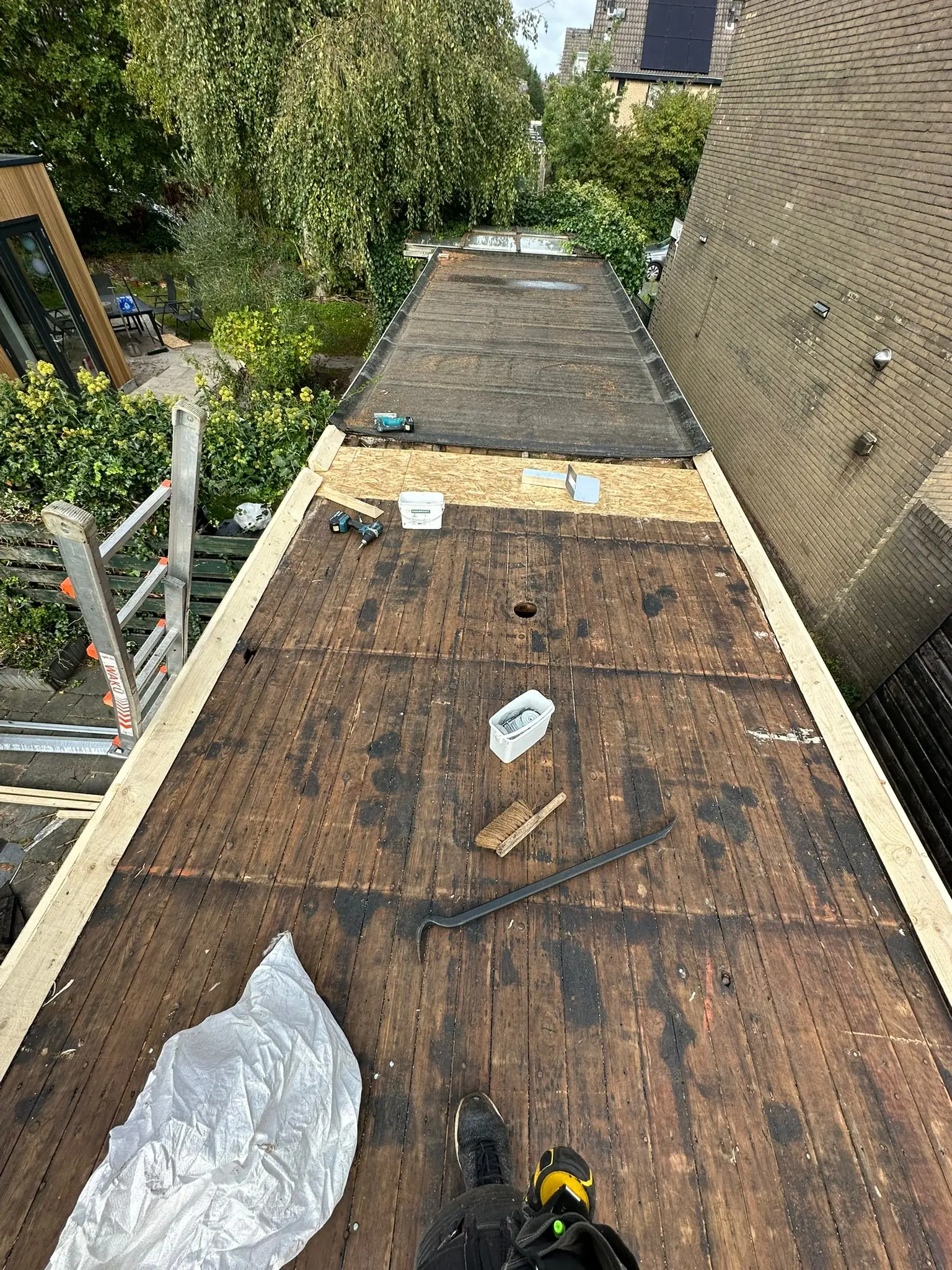 Dakinspectie na storm met dakdekker die dakpannen controleert op stormschade